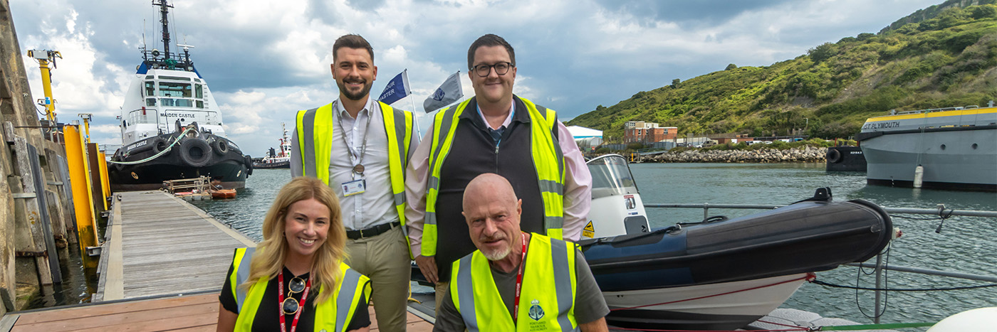 photo of four people in hi-vis by a harbour