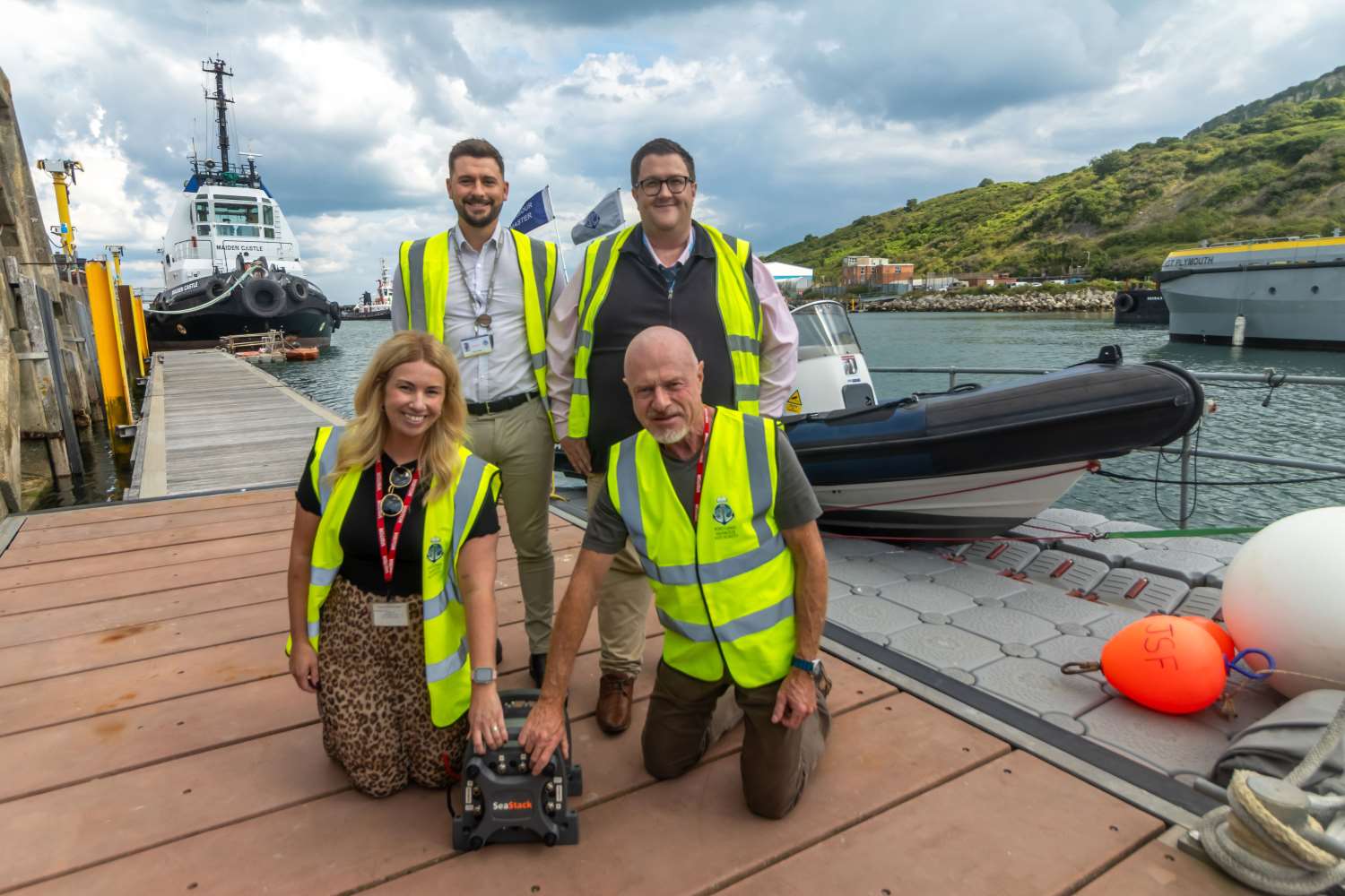 photo of four people in hivis by a harbour